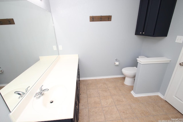 bathroom featuring toilet, tile patterned floors, vanity, and baseboards