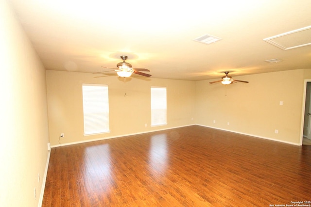 spare room with wood finished floors, ceiling fan, baseboards, and visible vents