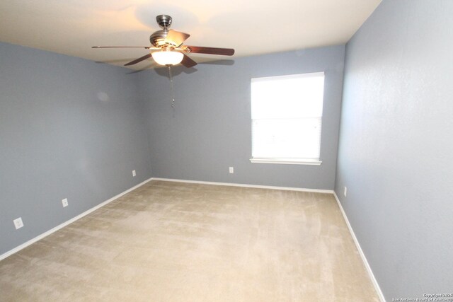 empty room with baseboards, light colored carpet, and a ceiling fan