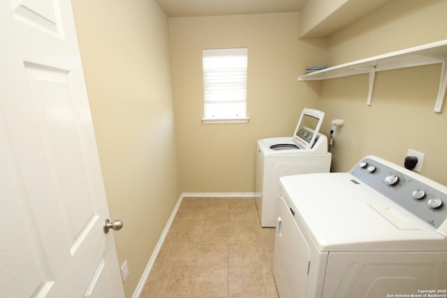 washroom with baseboards, washer and dryer, and laundry area