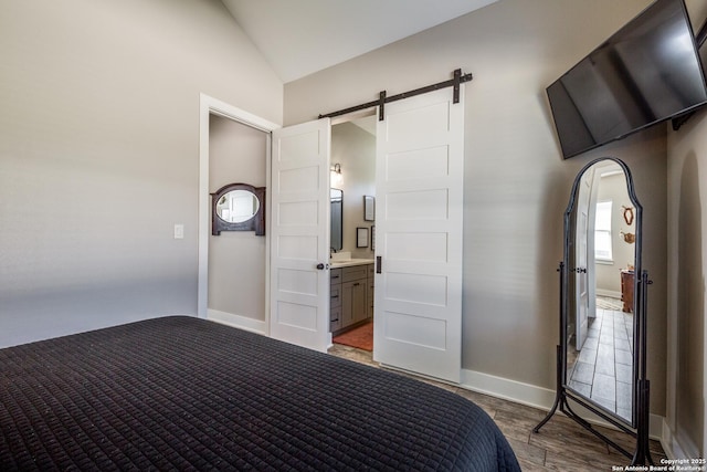 112 Chinkapin, Boerne, TX 78006 - bedroom featuring baseboards, vaulted ceiling, a barn door, arched walkways, and a sink