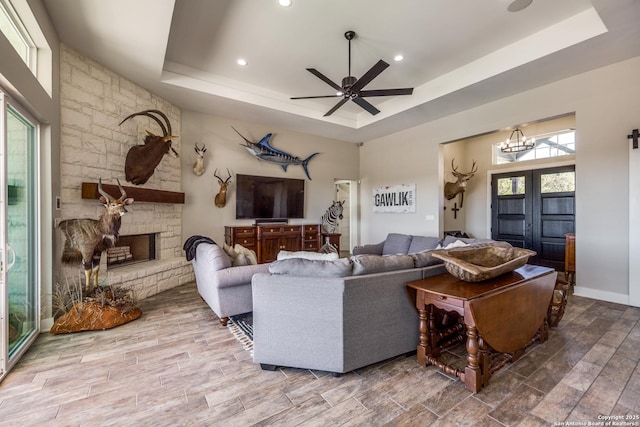 112 Chinkapin, Boerne, TX 78006 - living room featuring recessed lighting, a fireplace, a tray ceiling, ceiling fan with notable chandelier, and wood finished floors