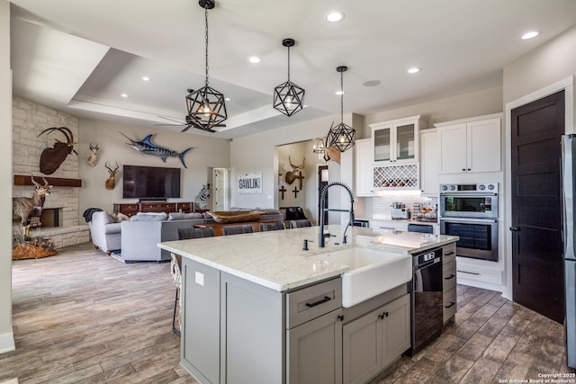 112 Chinkapin, Boerne, TX 78006 - kitchen with a fireplace, gray cabinetry, a tray ceiling, dark wood finished floors, and a sink