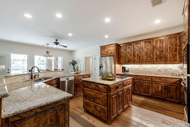 kitchen featuring visible vents, a large island, a sink, appliances with stainless steel finishes, and a ceiling fan