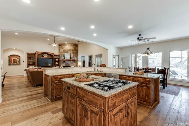 kitchen with a fireplace, a large island, a ceiling fan, and gas stovetop