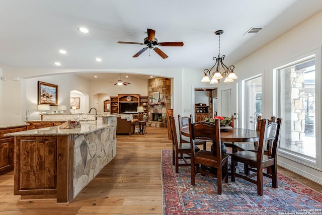 dining area featuring visible vents, a ceiling fan, arched walkways, and a healthy amount of sunlight