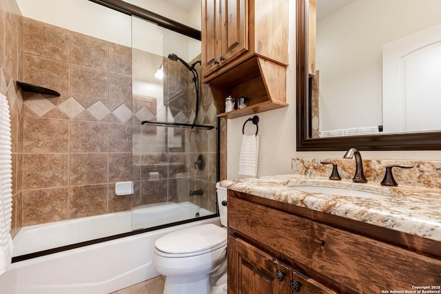 full bath with shower / bath combination with glass door, vanity, and toilet