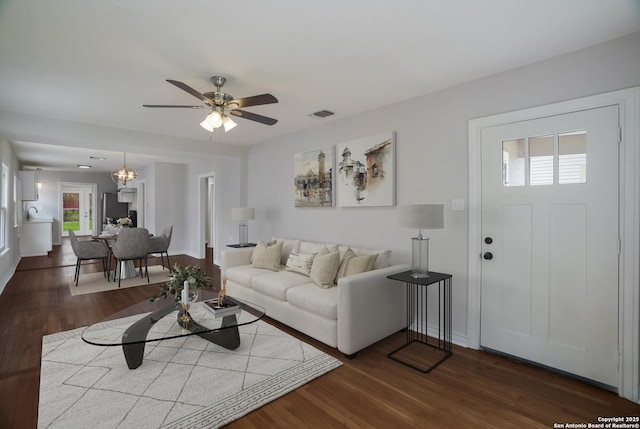 living area featuring dark wood-style floors, baseboards, visible vents, and ceiling fan