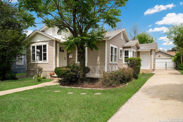bungalow-style home with a garage, a front yard, fence, and a gate