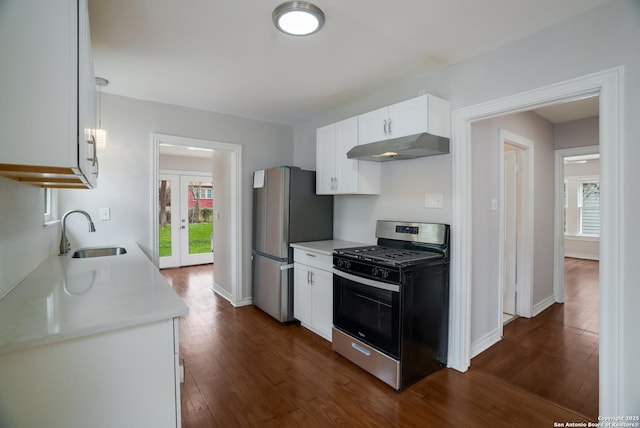 kitchen with french doors, light countertops, under cabinet range hood, stainless steel appliances, and a sink