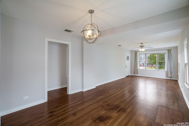 empty room featuring visible vents, baseboards, ceiling fan with notable chandelier, and dark wood finished floors