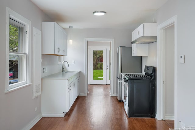 kitchen featuring stainless steel range with gas stovetop, white cabinets, a sink, light countertops, and wood finished floors