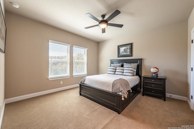 carpeted bedroom featuring baseboards and a ceiling fan