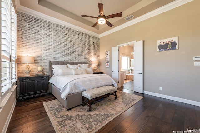 bedroom featuring a tray ceiling, dark wood-style flooring, baseboards, and visible vents