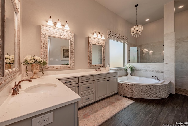 full bathroom with a sink, a bath, a walk in shower, and double vanity