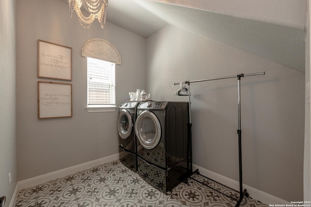 washroom with laundry area, light tile patterned floors, a chandelier, baseboards, and washing machine and dryer