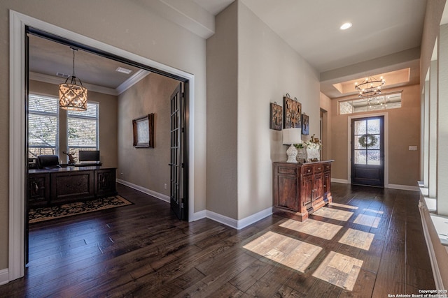 foyer featuring a chandelier, hardwood / wood-style flooring, baseboards, and ornamental molding