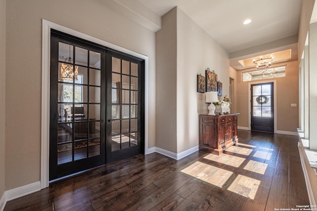 entryway with wood-type flooring, baseboards, and an inviting chandelier