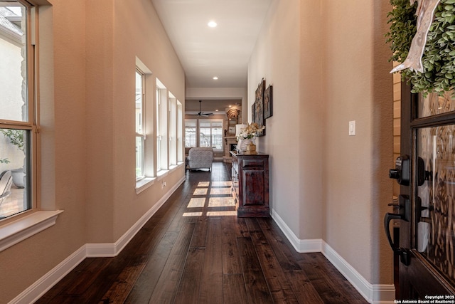 corridor with recessed lighting, dark wood-type flooring, and baseboards