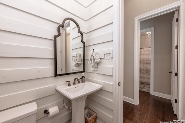 full bathroom featuring baseboards, a sink, toilet, and wood finished floors