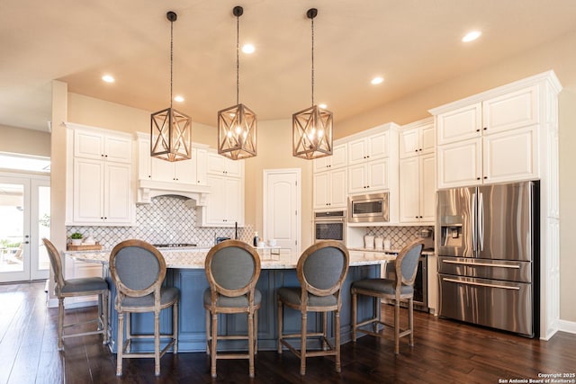 kitchen featuring stainless steel appliances, white cabinetry, and a spacious island