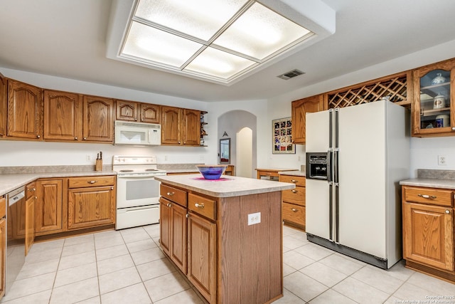 10 Oakwell Farms Pkwy, San Antonio, TX 78218 - kitchen featuring brown cabinetry, arched walkways, white appliances, and visible vents
