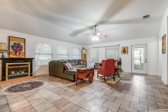 10 Oakwell Farms Pkwy, San Antonio, TX 78218 - living area featuring visible vents, baseboards, a ceiling fan, vaulted ceiling, and a glass covered fireplace