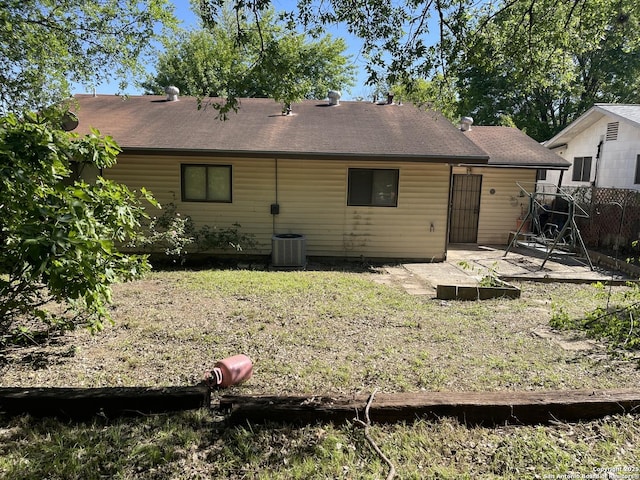 back of property featuring central AC unit, roof with shingles, fence, and a patio area