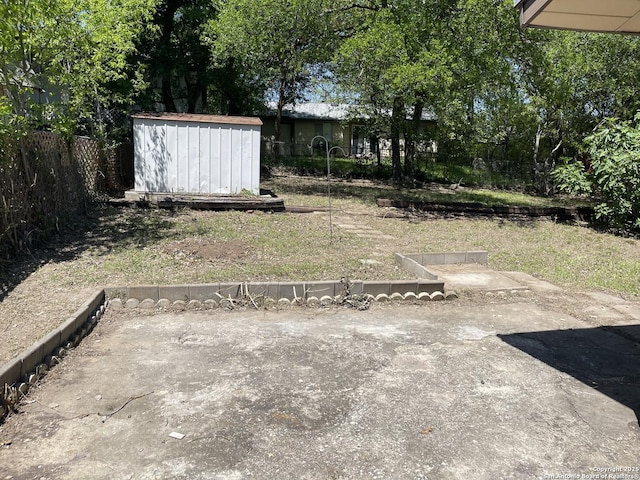 view of yard with an outbuilding, fence, and a storage unit