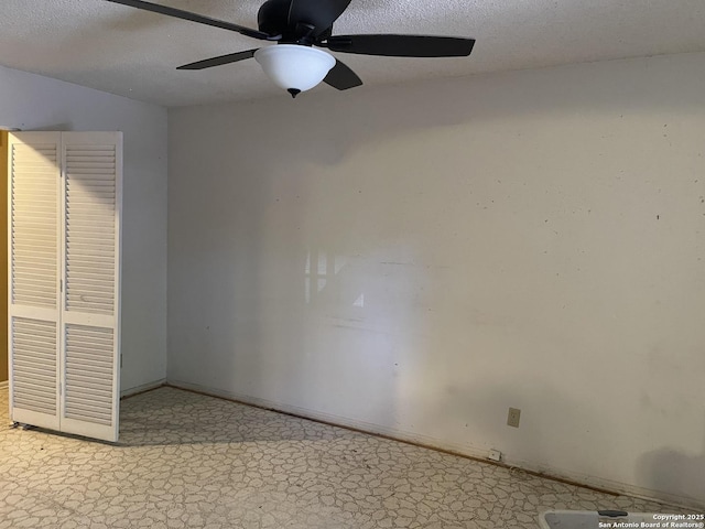 spare room featuring a textured ceiling, ceiling fan, and baseboards