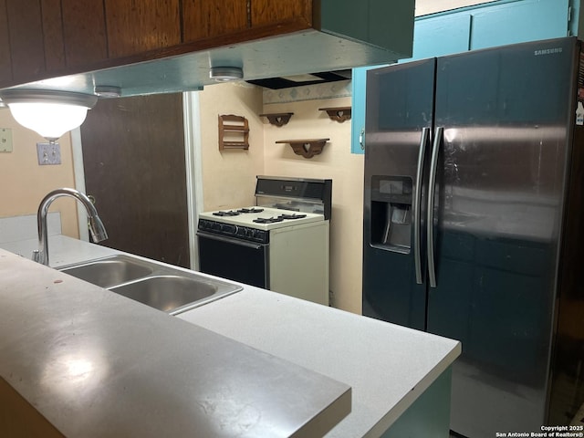 kitchen featuring black fridge, a sink, and white gas range oven