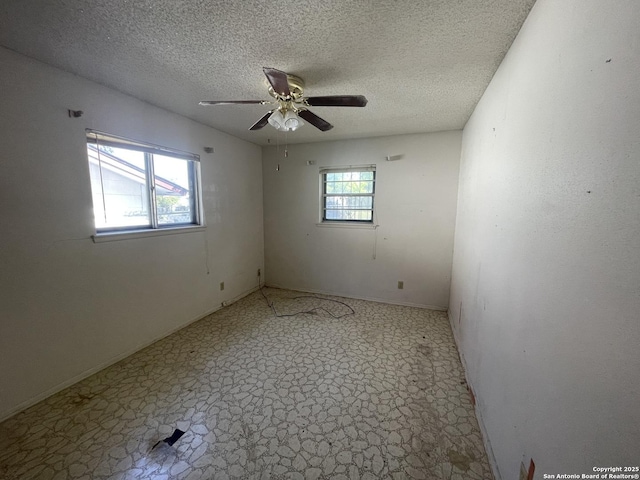 unfurnished room featuring a textured ceiling, ceiling fan, and a wealth of natural light