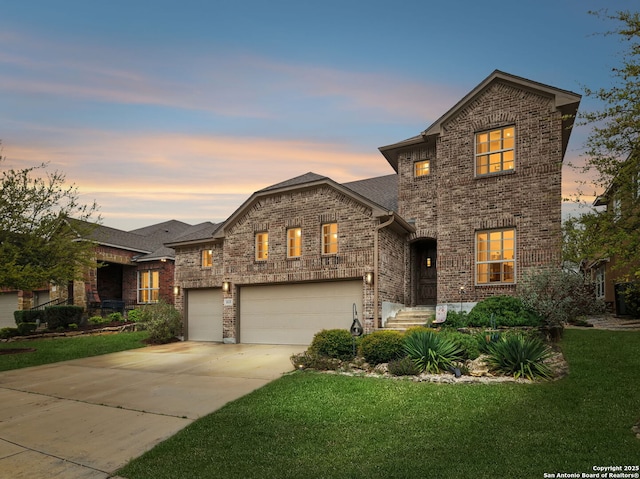view of front of property featuring an attached garage, driveway, a front lawn, and brick siding