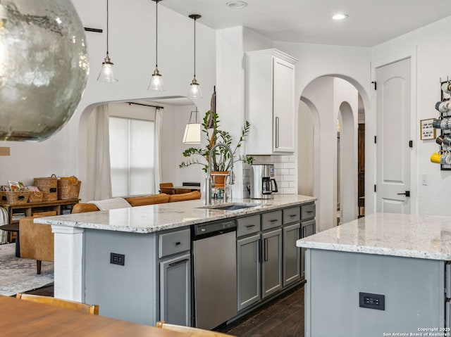 kitchen with dark wood-style flooring, backsplash, gray cabinetry, arched walkways, and dishwasher