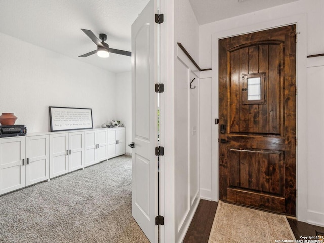 carpeted entryway featuring a ceiling fan