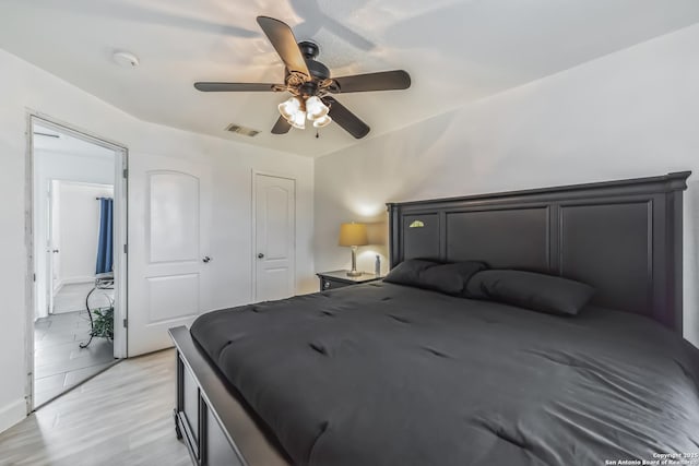 bedroom with visible vents, light wood-type flooring, and a ceiling fan