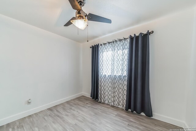 empty room with baseboards, ceiling fan, and wood finished floors