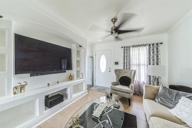 living room featuring built in features, ceiling fan, a textured ceiling, crown molding, and light tile patterned flooring