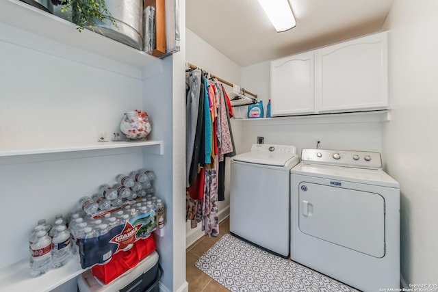 washroom featuring cabinet space, light tile patterned floors, and washing machine and clothes dryer