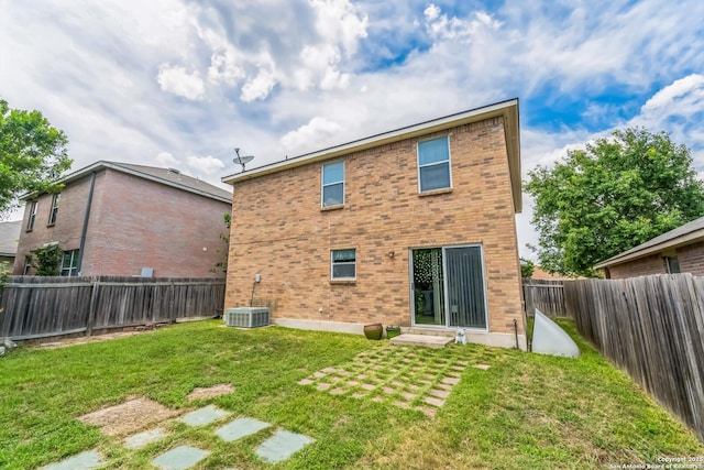rear view of house featuring a yard, brick siding, a fenced backyard, and entry steps