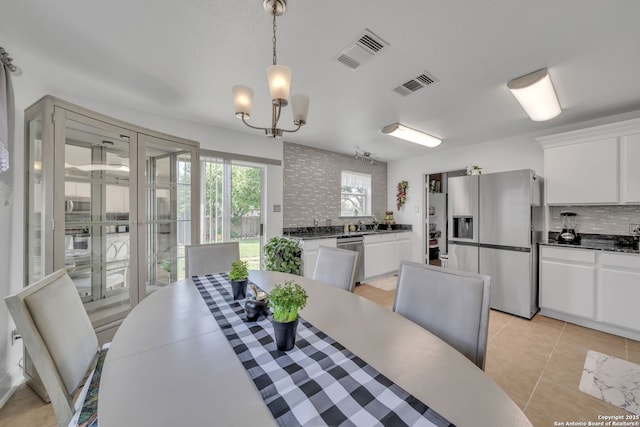 dining area featuring visible vents, a chandelier, and light tile patterned floors