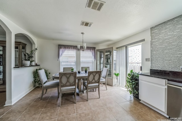 dining space featuring a textured ceiling, light tile patterned flooring, and visible vents