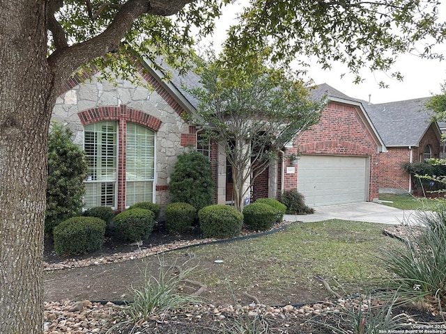 23407 Treemont Park, San Antonio, TX 78261 - view of front of home with stone siding, a garage, driveway, brick siding, and roof with shingles