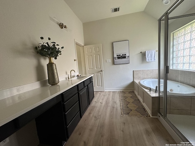 23407 Treemont Park, San Antonio, TX 78261 - bathroom featuring wood finished floors, a whirlpool tub, a shower stall, lofted ceiling, and double vanity