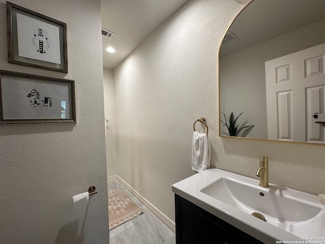 23407 Treemont Park, San Antonio, TX 78261 - bathroom with a textured wall, vanity, and marble finish floors