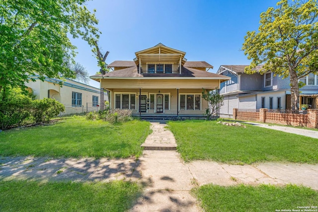 view of front of property featuring covered porch, a front yard, and fence