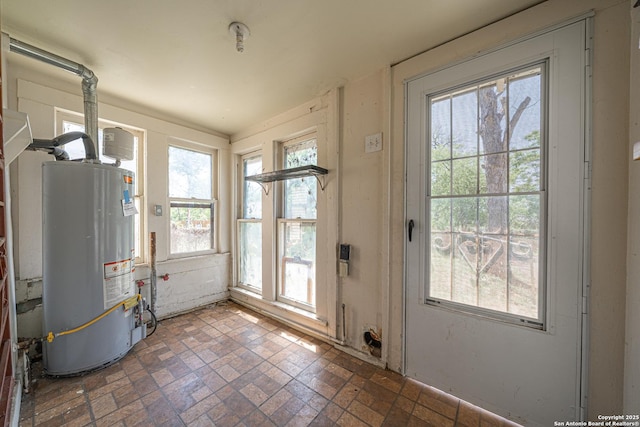entryway with water heater and brick patterned floor