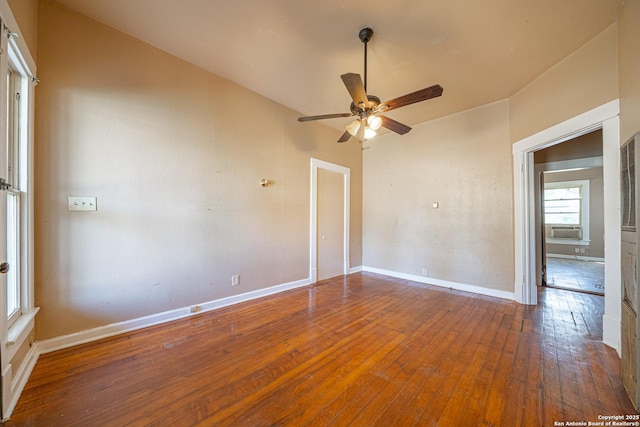 empty room with cooling unit, wood-type flooring, a ceiling fan, and baseboards