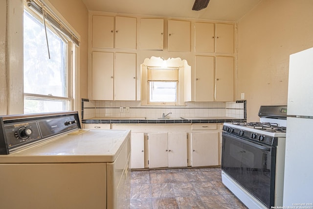 kitchen featuring decorative backsplash, range with gas stovetop, plenty of natural light, and cream cabinets
