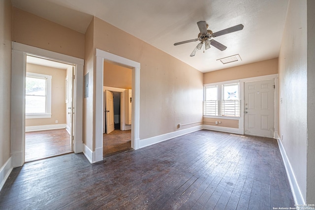 interior space featuring visible vents, ceiling fan, baseboards, and dark wood-style floors